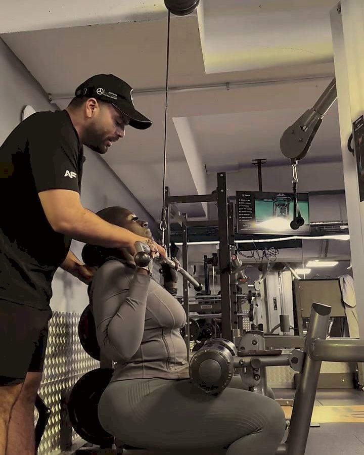 Pablo guiding a client's cable squat.