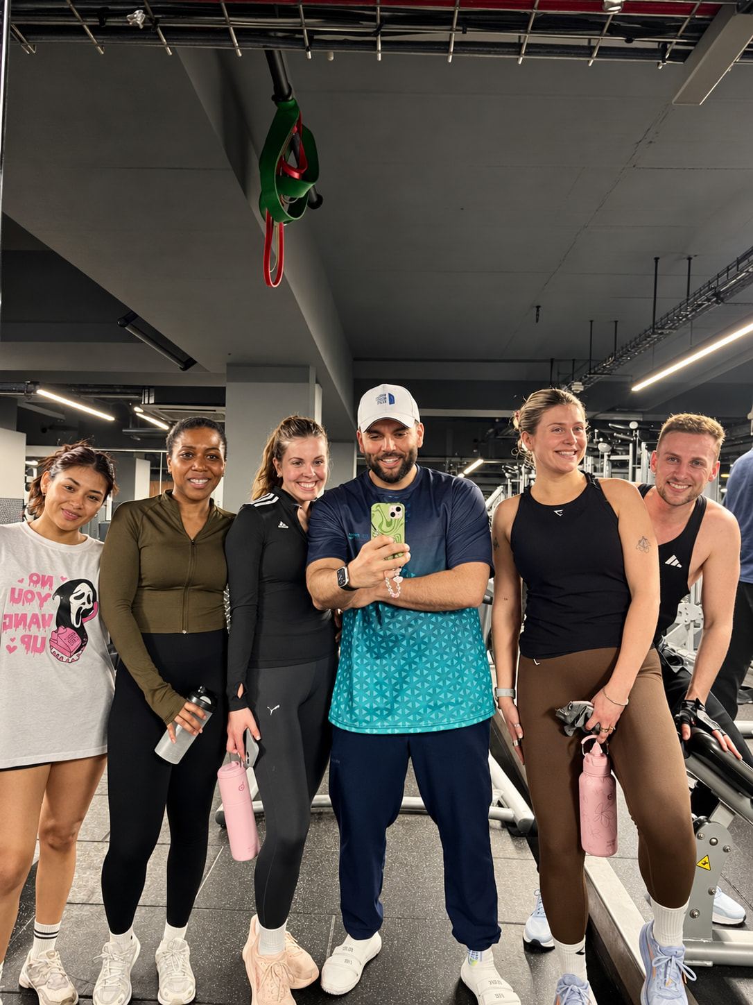 Pablo with five smiling clients after a small-group session, taking a mirror selfie.