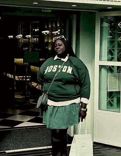 Nacks before starting, standing in a shop doorway in a green sweatshirt.